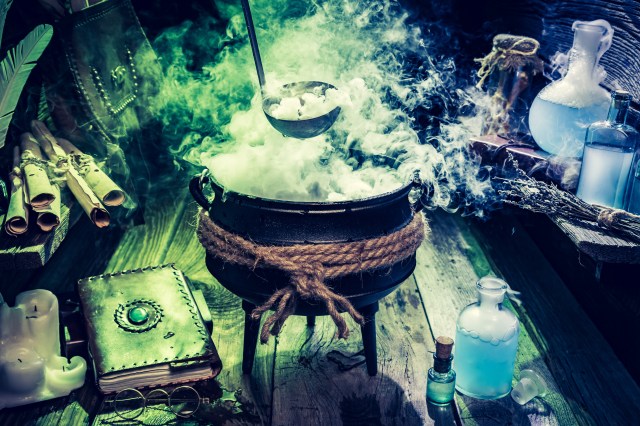 Mysterious witch pot with blue potions and books for Halloween