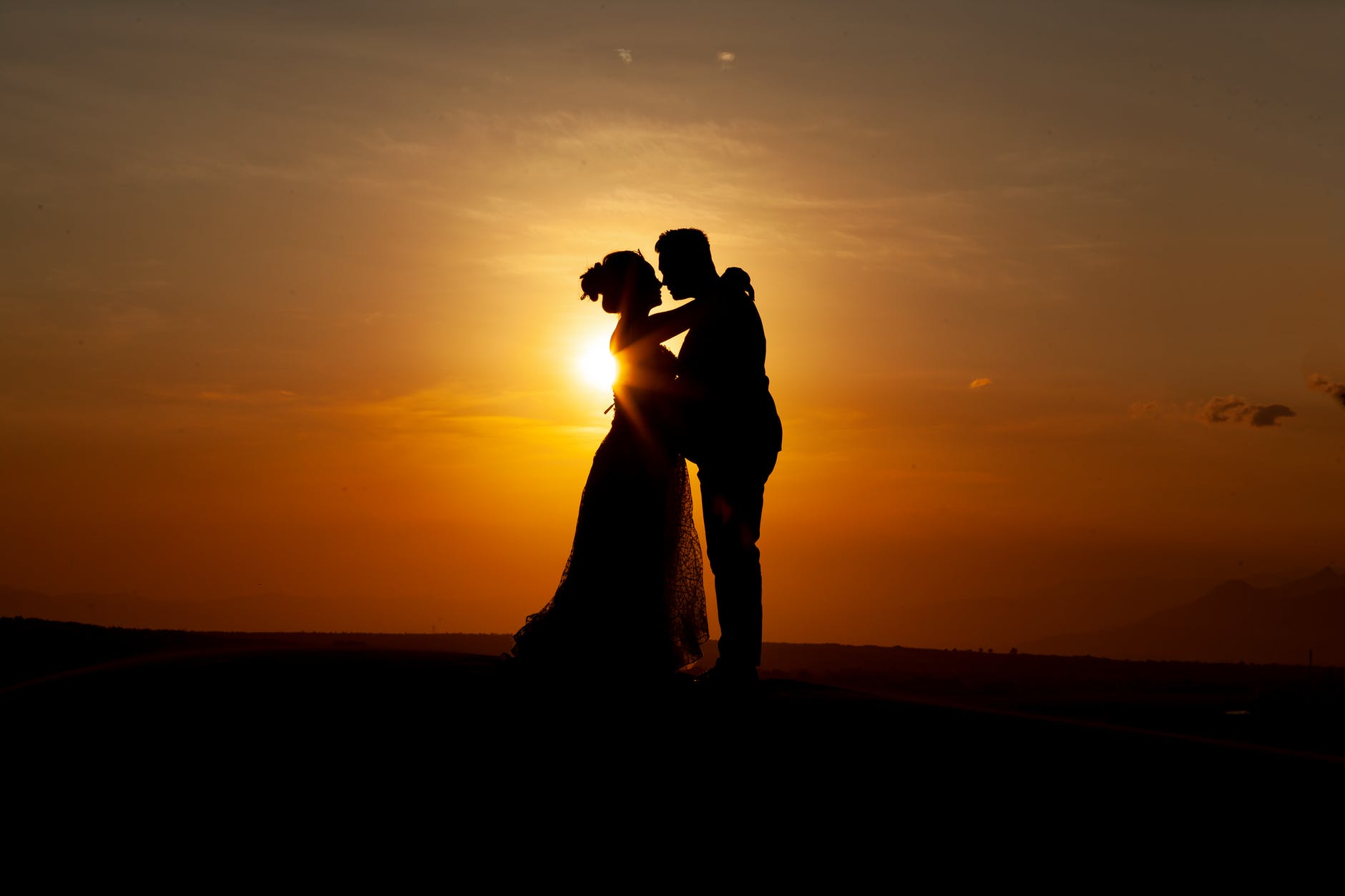 silhouette of couple kissing during sunset